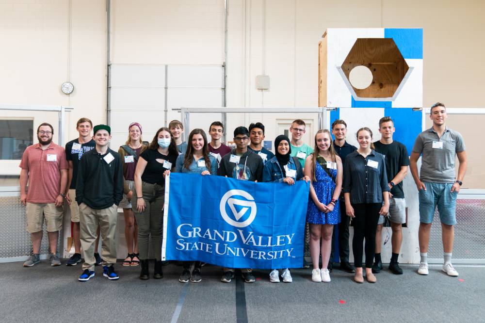 Students pose with the GVSU flag